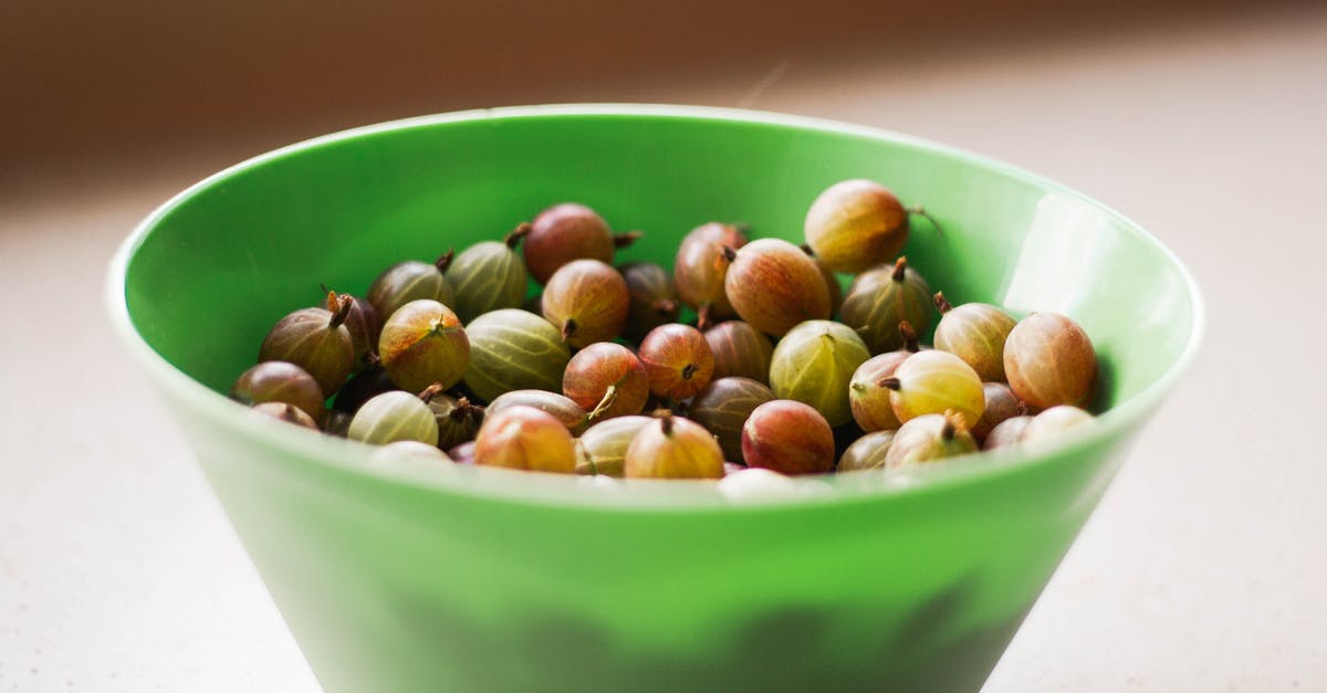 Vegetarian Alternative to Bacon-wrapped Sausages? - High angle of ripe gooseberries in green deep plastic bowl on table on summer day