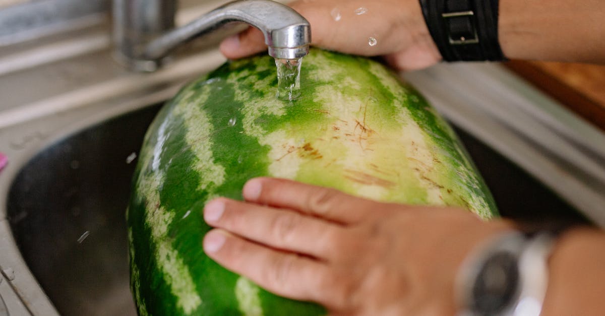 Washing fruit after cutting? - Person Washing a Watermelon in the Sink