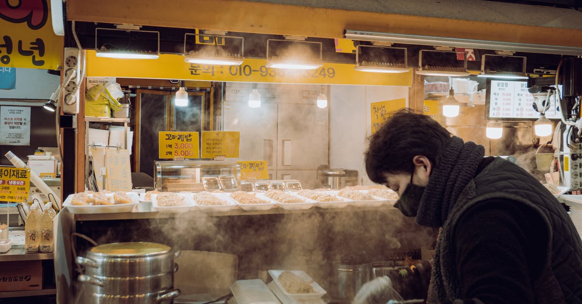 Water collects around cooked idlis in my steamer - A Woman Preparing Packed Foods in a Food Stall