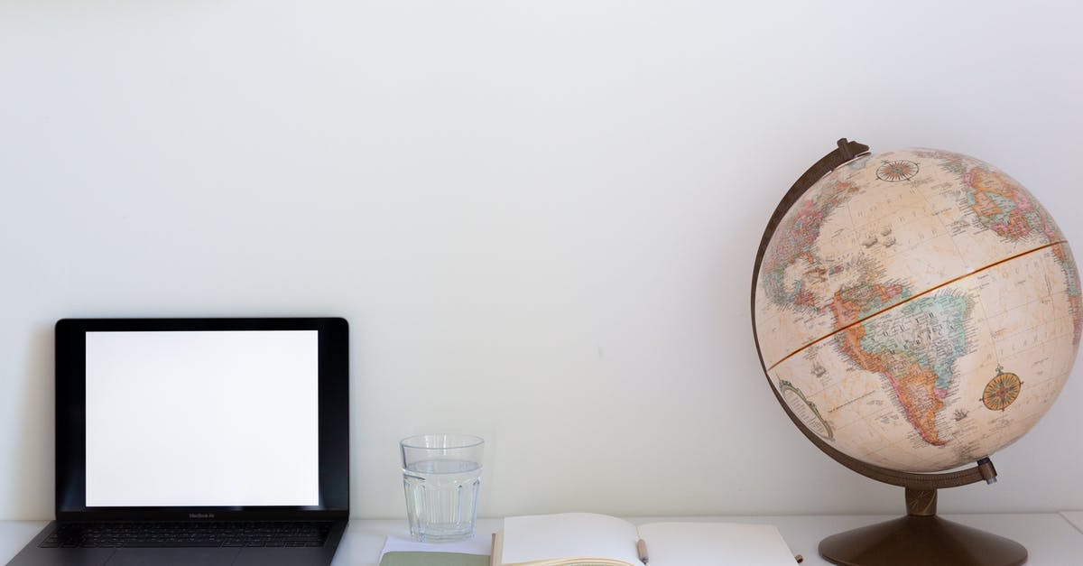 Water seal vs open crock pickles - Creative composition of computer with empty screen placed near notebook with white papers and globe with glass of water in between