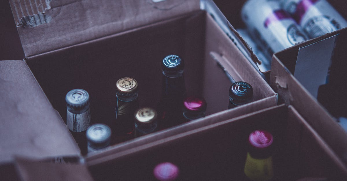 What's different between canned beer and bottled beer? - Glass Bottles on Boxes Close-up Photography