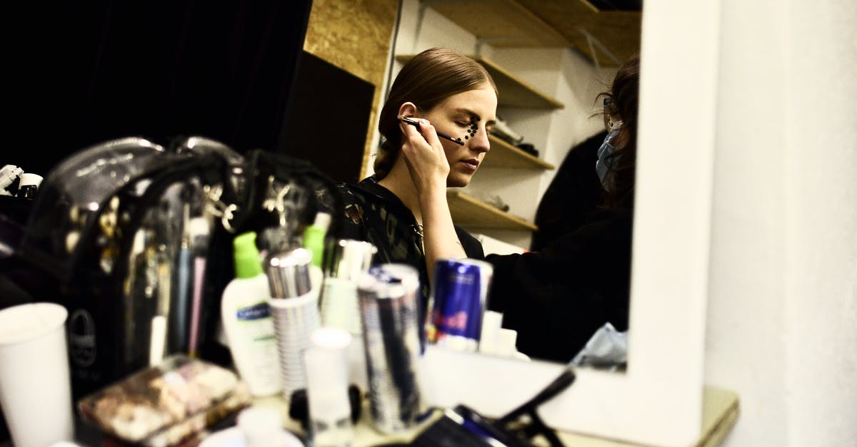 What's the correct temperature to prepare confit cod? - Reflection of female visagiste with brush applying makeup on face of model in dressing room