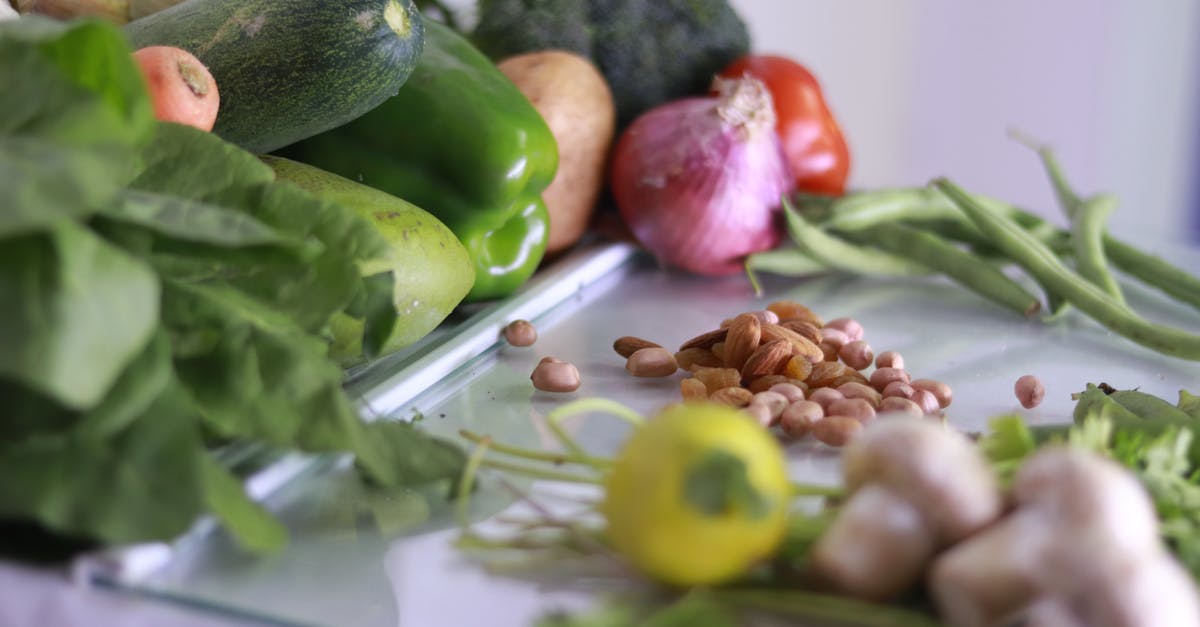 What's the difference between broccoli from China and broccoli from Australia? - From above of various fresh organic colorful vegetables and nuts placed on glass tabletop in light kitchen