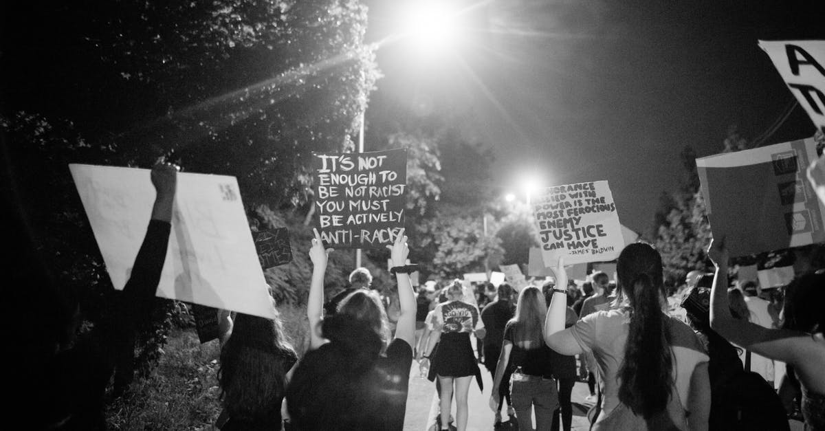 What's the right way to add extra gluten to dough? - Back view of black and white crowd of unrecognizable protesting people walking on street with banners during anti racism demonstration