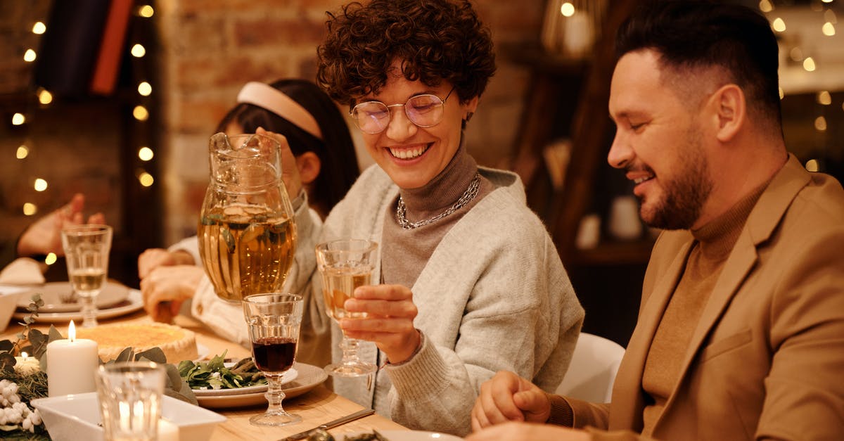 What's the secret to getting restaurant-quality frozen drinks at home? - Woman in Gray Sweater Sitting Beside Man in Brown Blazer