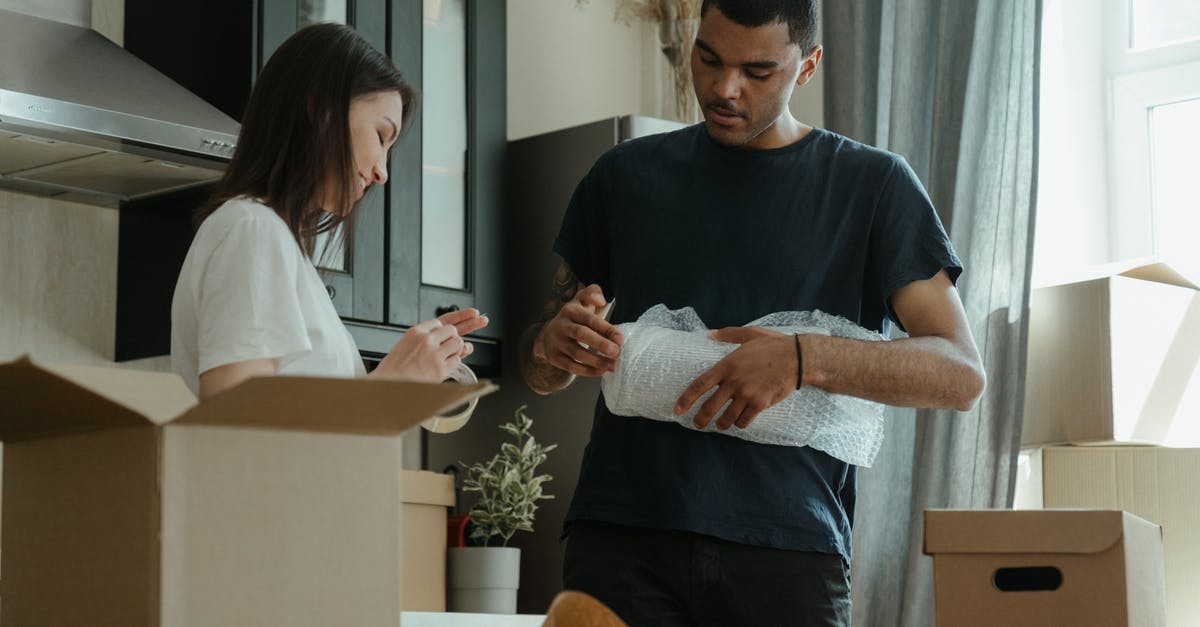 What's the trick to wrapping tightly in plastic wrap? - Man in Blue Crew Neck T-shirt Holding Woman in White Long Sleeve Shirt