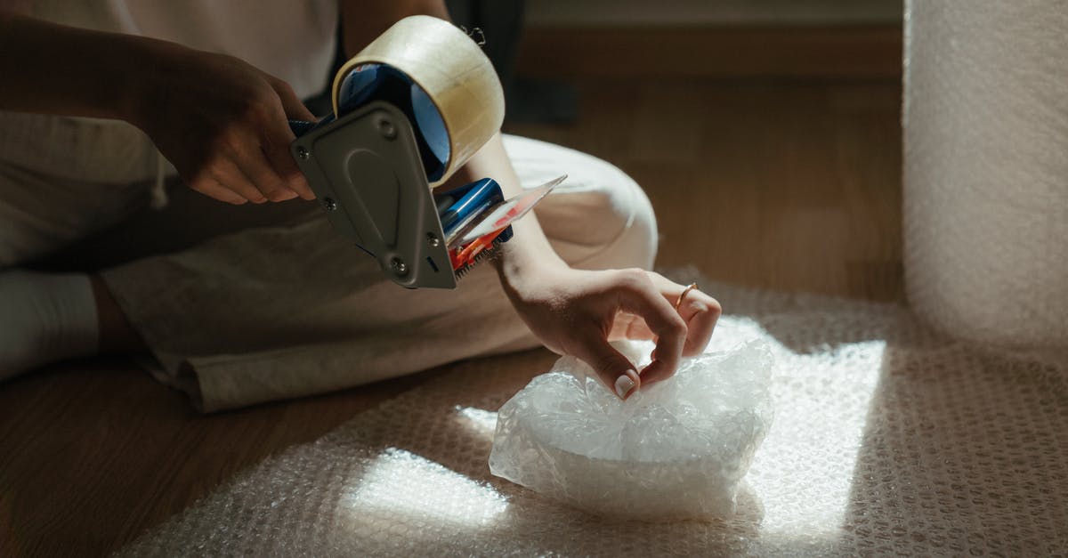 What's the trick to wrapping tightly in plastic wrap? - Person Holding White and Black Vr Goggles