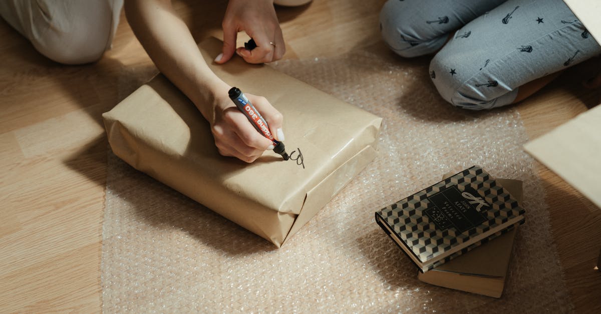 What's the trick to wrapping tightly in plastic wrap? - Person in Blue Denim Jeans Holding Black Pen