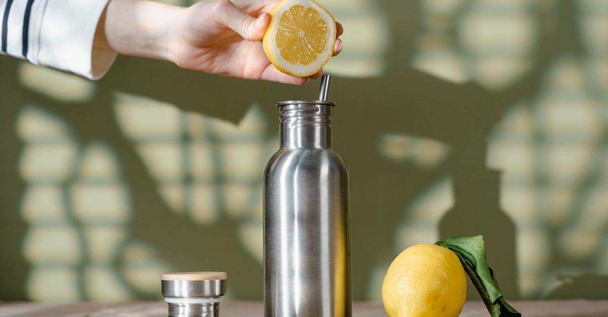 What alternatives do exists for properly squeezing lemons? - Person Squeezing Lemon on Stainless Steel Water Bottle