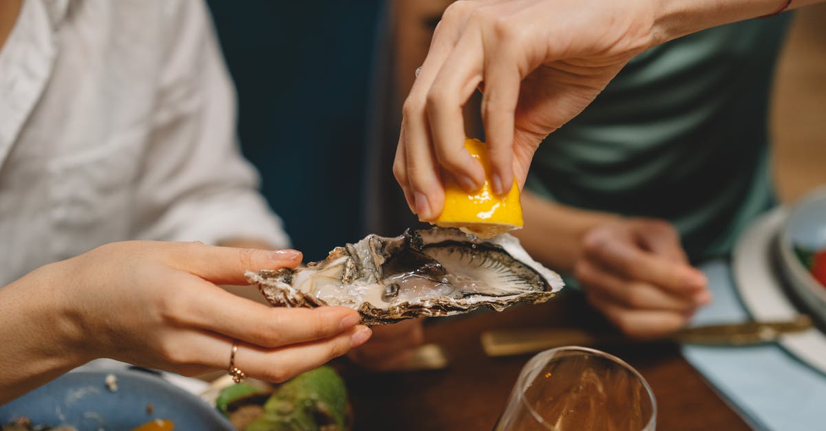 What alternatives do exists for properly squeezing lemons? - A Person Squeezing Lemon on an Oyster