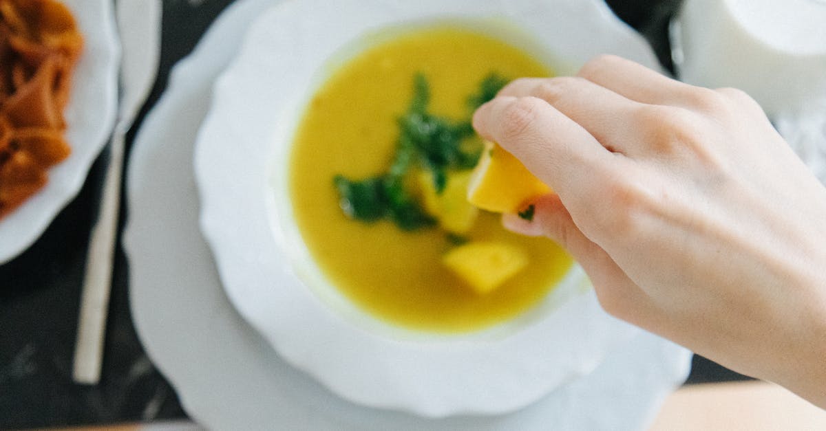 What alternatives do exists for properly squeezing lemons? - A Person Squeezing a Lemon on Lentil Soup