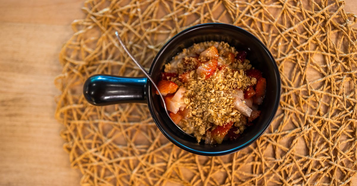 What are berry grains? - Top view of black ceramic plate of delicious mix of granola and strawberry placed on wooden table on morning breakfast