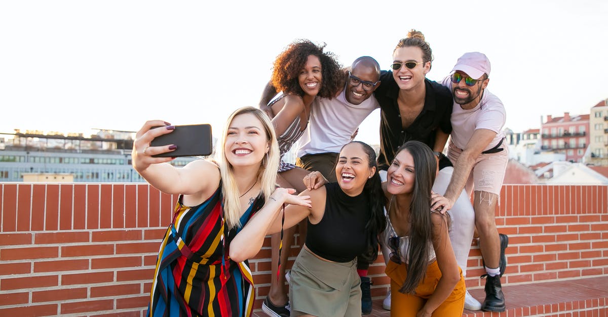 What are best practices for using Yoghurt as a Marinade? - Group of cheerful young male and female multiracial friends laughing and taking selfie on smartphone while spending time together on terrace