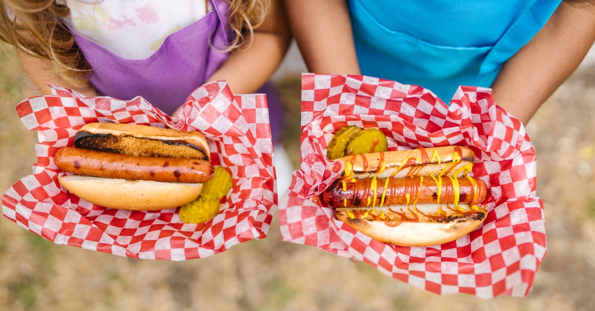 What are bologna and hotdogs really made of? - Woman in Teal Tank Top Holding Burger