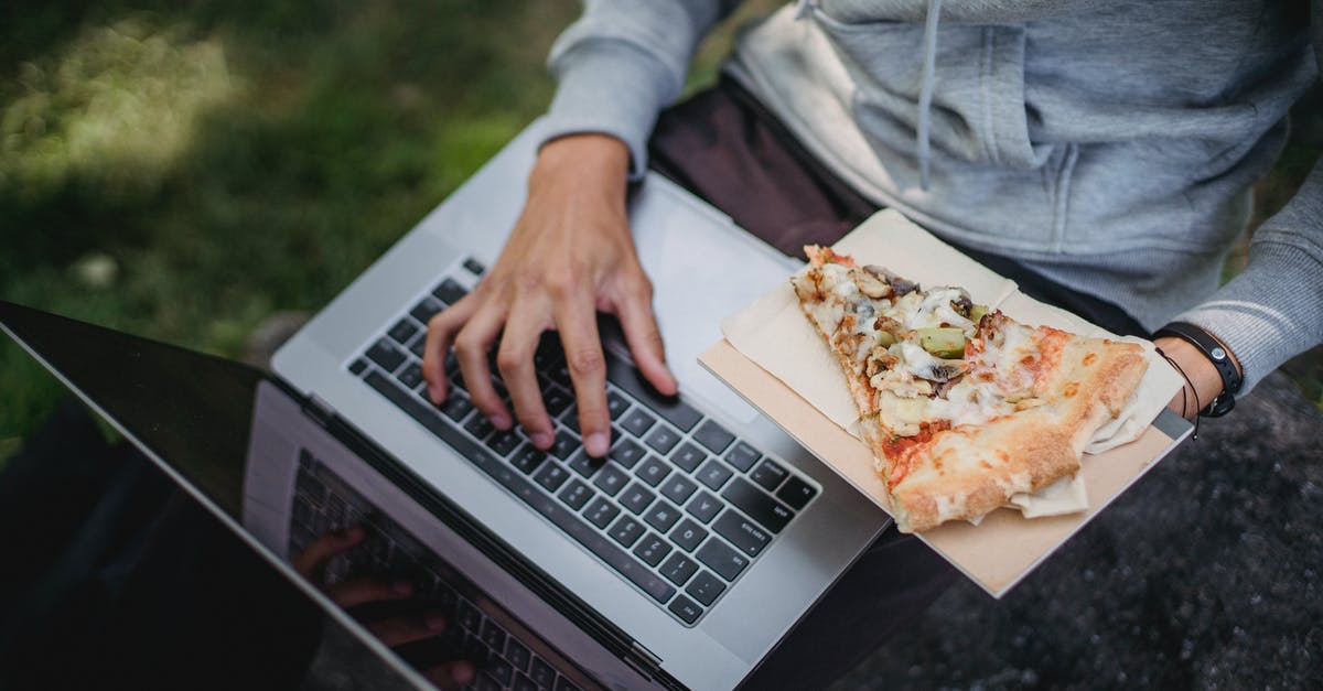 What are good resources to learn food chemistry? - From above of crop anonymous learner using laptop for studies and eating pizza in park