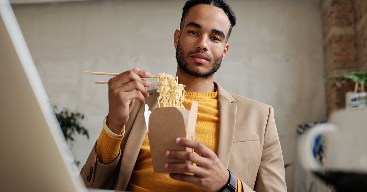 What are Maggi noodles and what's a good bulk substitute? - Man in Brown Blazer holding a Food Takeout 