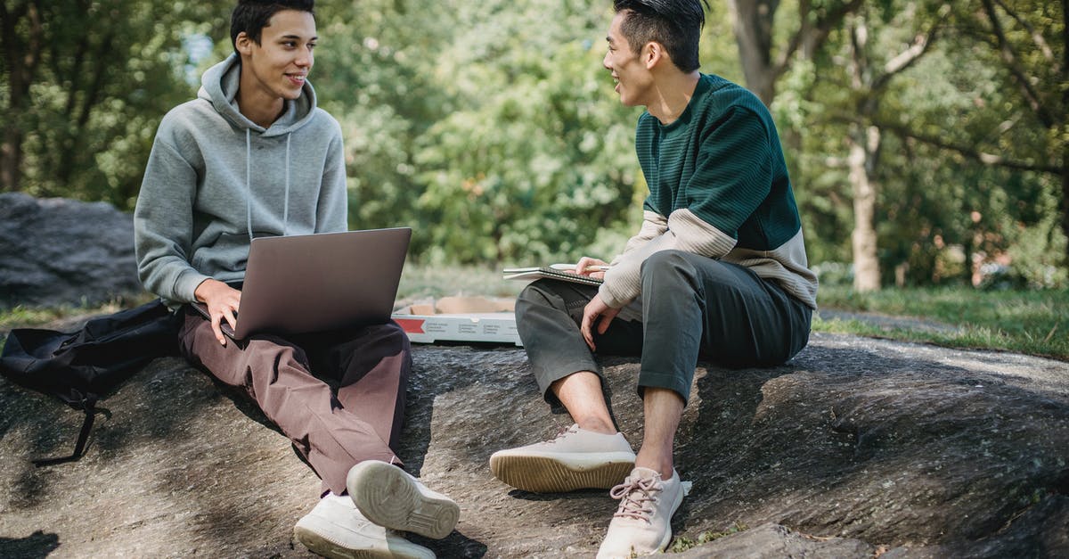 What are other uses for a pizza stone? - Full body of positive multiracial classmates sharing information on university assignment while browsing laptop in nature