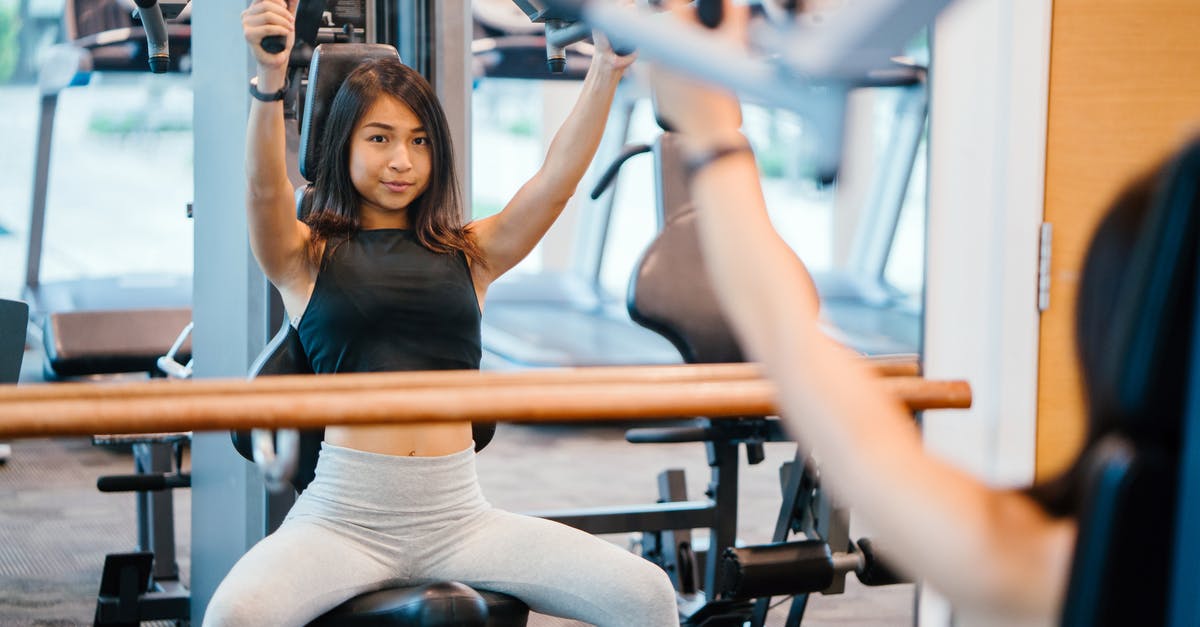 What are the 3 vents / weights on this Chinese pressure canner? - Woman in Black Sleeveless Crop-top and White Leggings Using a Butterfly Machine in Front of a Mirror