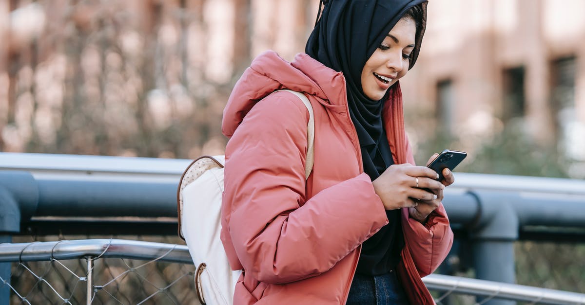What are the advantages and disadvantages to using a griddle instead of a cast-iron skillet? - Muslim ethnic female in hijab texting message on mobile phone near iron construction on blurred background of building