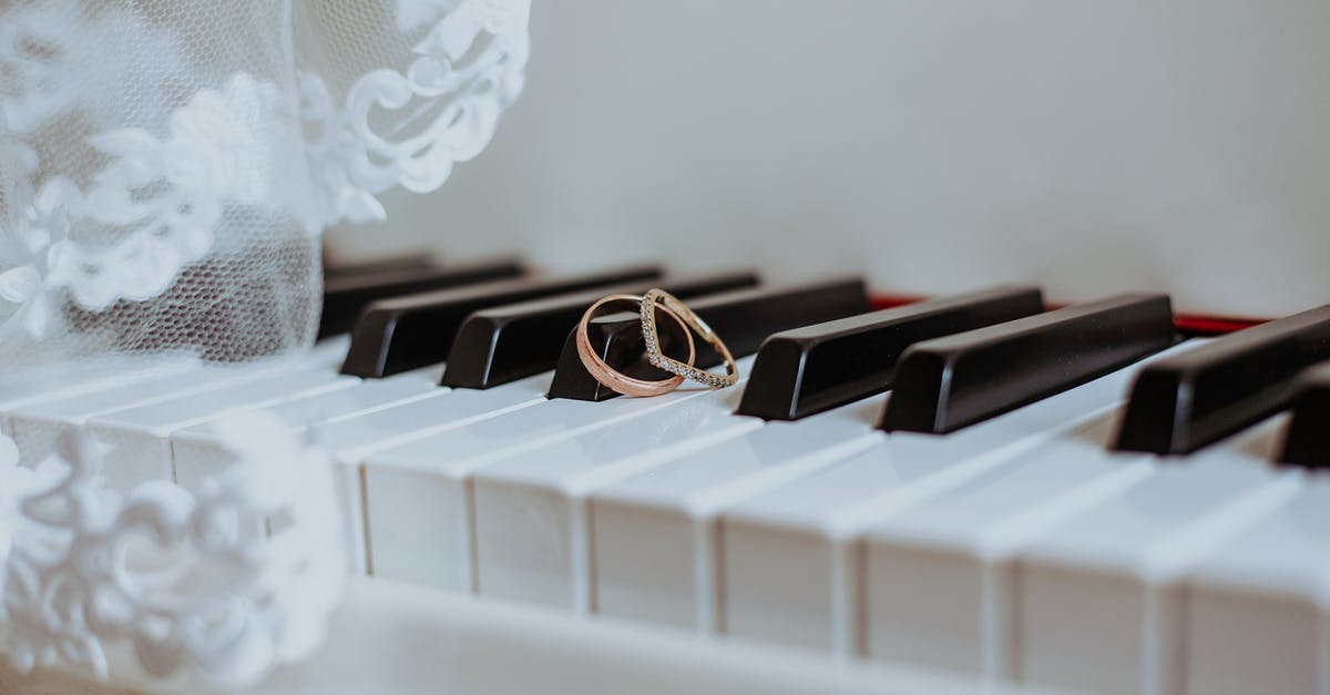 What are the differences between brown/golden sesame seeds and black ones? - Golden rings on piano keyboard under veil with ornament during festive event in daytime