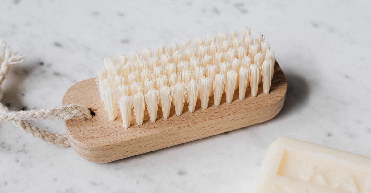What are the dos and don'ts regarding cleaning a bamboo cutting board? - Cleaning brush and soap on marble table
