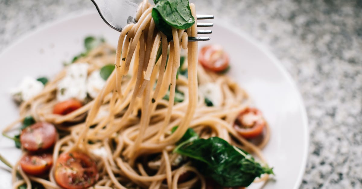 What are the hallmarks of a traditional alfredo sauce? - Selective Focus Photography of Pasta With Tomato and Basil