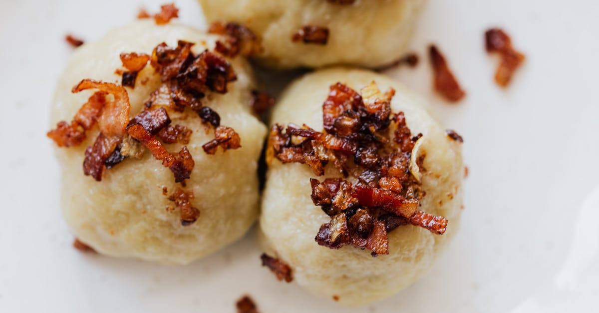 What are these crispy bits on top of rice? - Delicious dumplings with fried bacon slices on plate