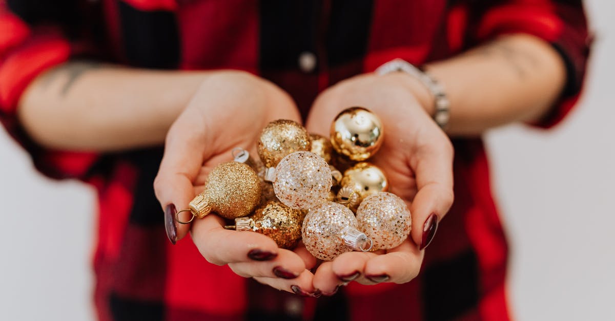 What are these little balls in my sardines? - Person Holding Silver and Gold Christmas Balls