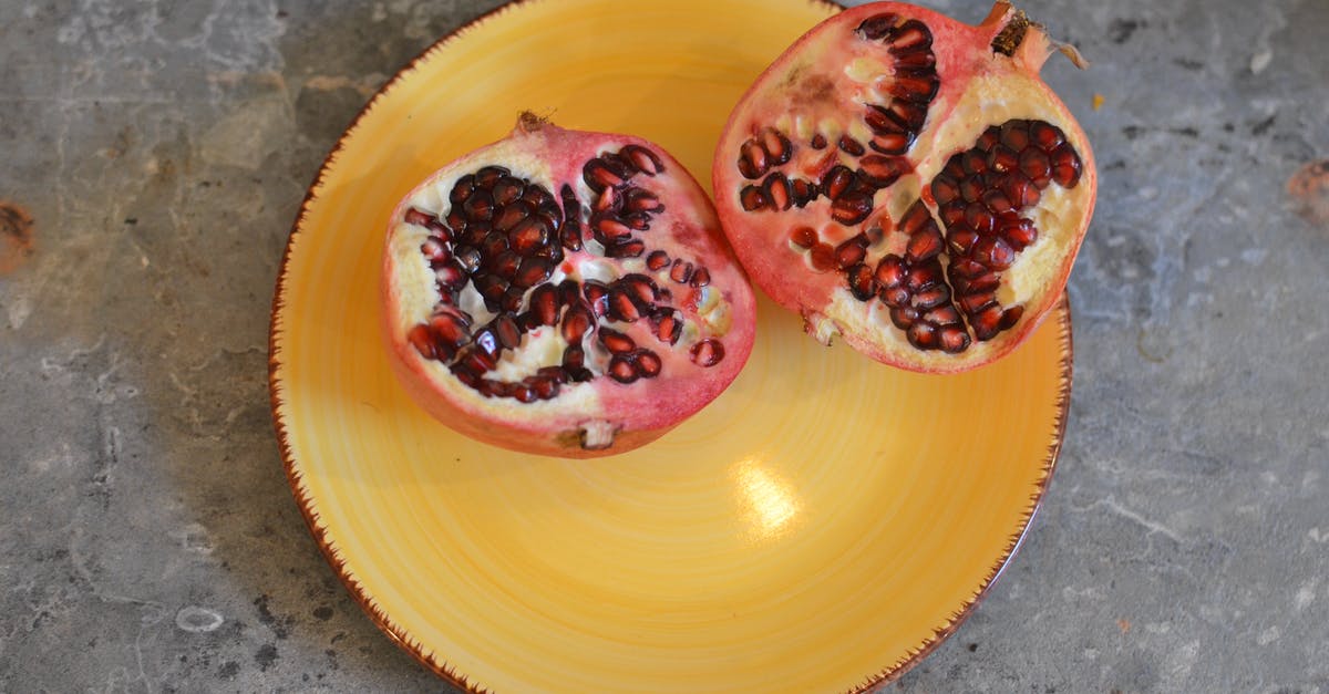 What are ways to extract the juice from a pomegranate? - Fresh pomegranate on yellow ceramic plate