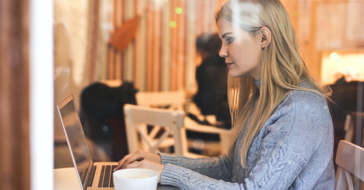 What can I use instead of a tea towel? - Serious young woman using netbook while having hot drink in modern cafe