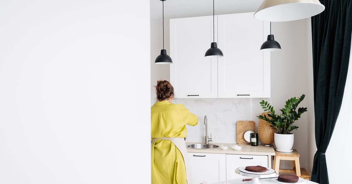 What causes a cake to sink in the center? - Woman in apron standing in kitchen