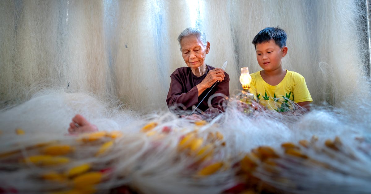 What causes butter to make risotto shiny? - Ethnic grandmother with needle weaving fishing net against boy