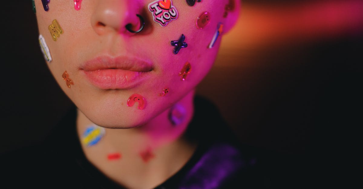 What causes odd off-flavor/smell in tofu? - Crop woman with multicolored stickers on face in dark studio