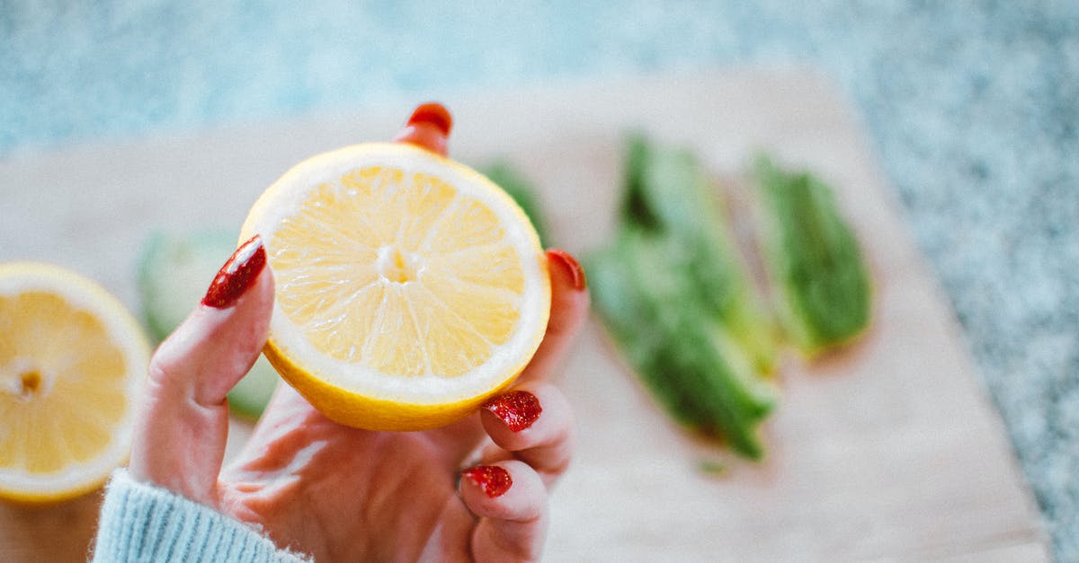 What could be the basic ingredients that potentiate sourness and bitterness? - Selective Focus Photography of Person Holding Sliced Lemon