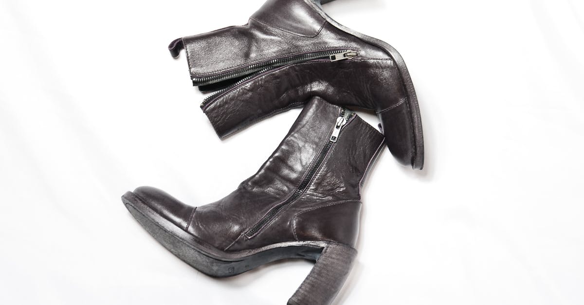 What could this utensil pair be used for? - Top view of pair of dark brown leather boots with zipper and wide high heels placed on white background