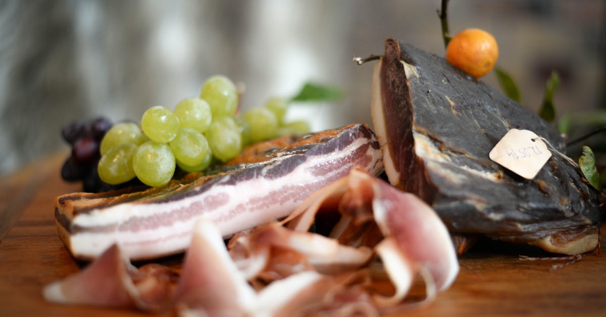 What cuts of meat are preferable when you want to avoid drying out? - Delicious jamon with grapes served on table