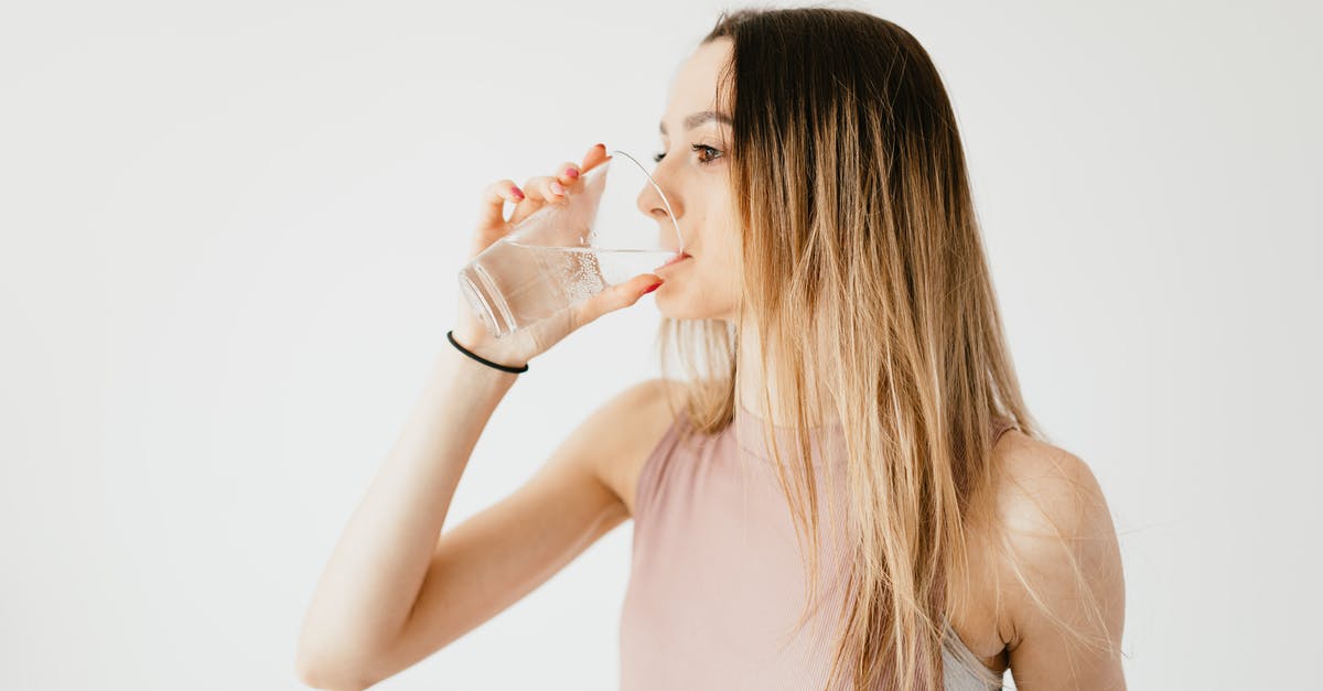What determines if something is easy to chew? A lot of liquid or totally dehydrated? - Young thirsty fit female with long hair in sportswear drinking water while recreating after workout
