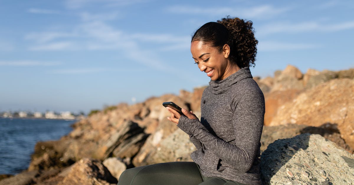 What difference would using Rock Sugar make in tea? - A Happy Woman Using her Cellphone while Sitting on a Rock