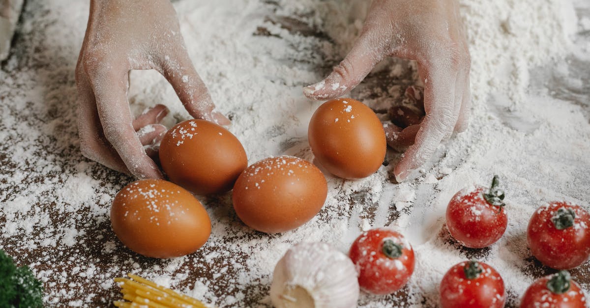What do you use to make tzatziki? Onions, garlic, or both? - From above of crop anonymous female cook taking eggs while preparing meal with cherry tomatoes garlic spaghetti and flour