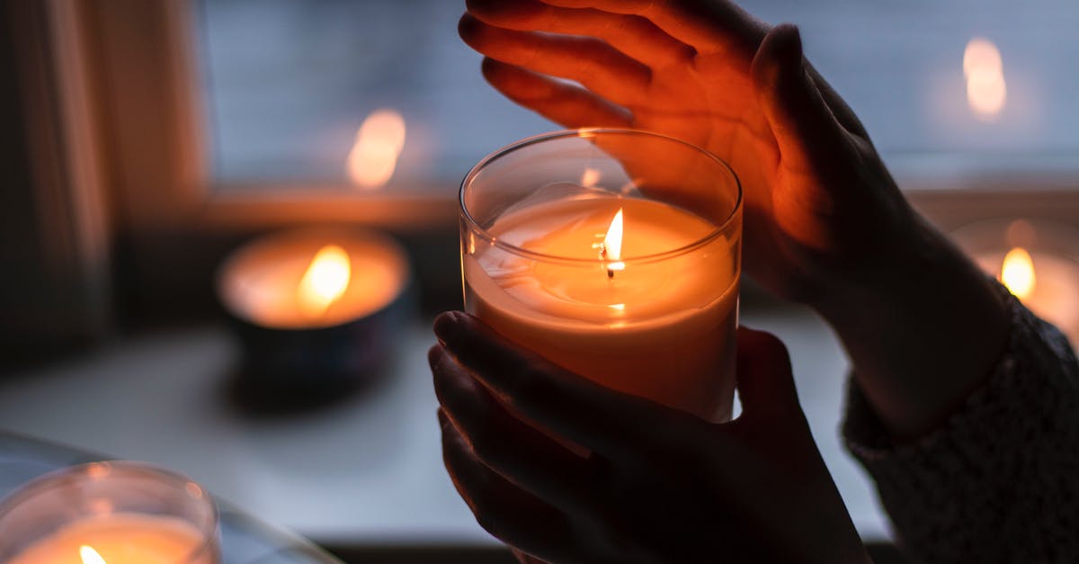 What does a Thai Scented Candle impart? - Photo of Person Holding Scented Candle