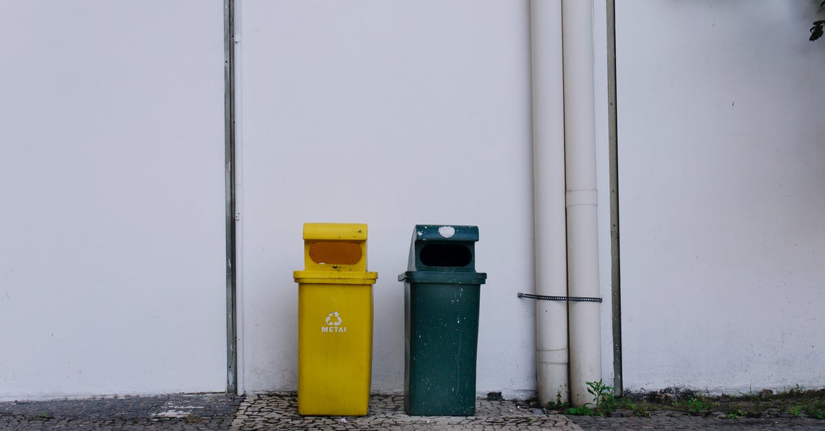 What does the clock-like symbols under plastic containers mean? - Trash Bins Beside a White Wall