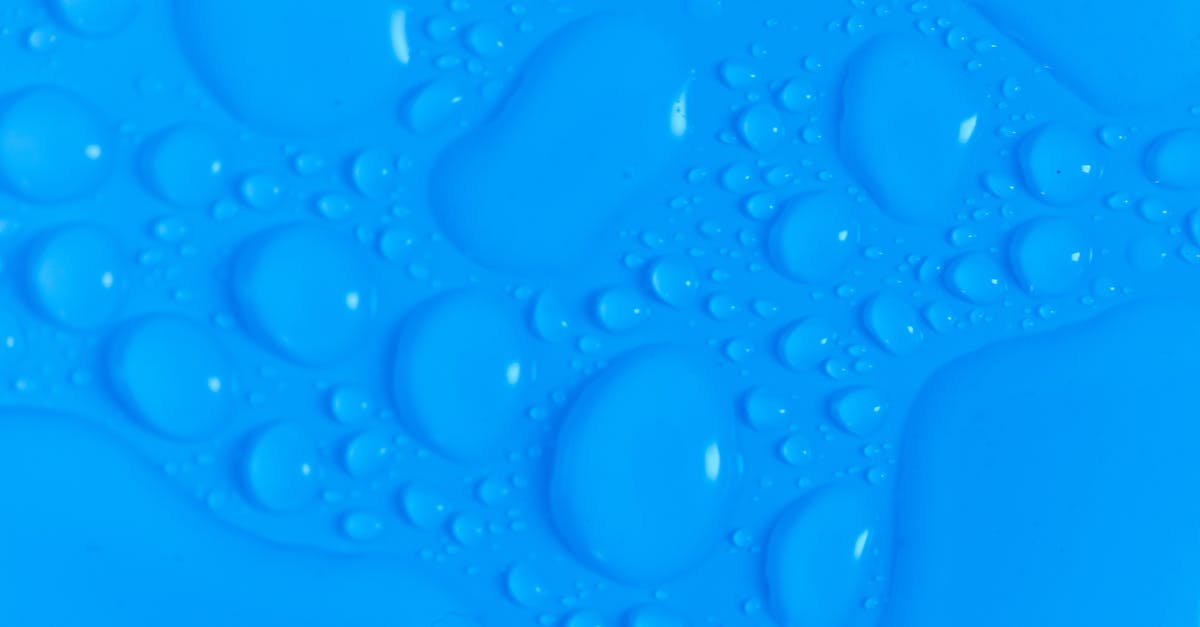 What effect do different slash patterns have on bread oven spring? - Closeup top view of dark blue wet blurred background with still shiny abstract transparent fluid drops of different sizes and shapes