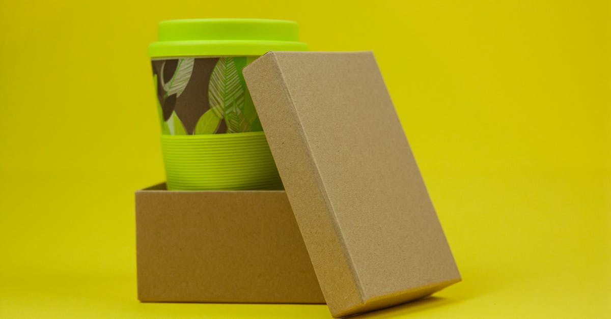 What exactly are Bamboo shoots? - Reusable eco green bamboo cup with leaves in carton box on yellow background in light studio