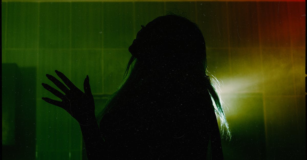 What flavorants stand up to long cooking? - Side view silhouette of female throwing head back and raising hand with spread fingers while standing in dark room against dim green light