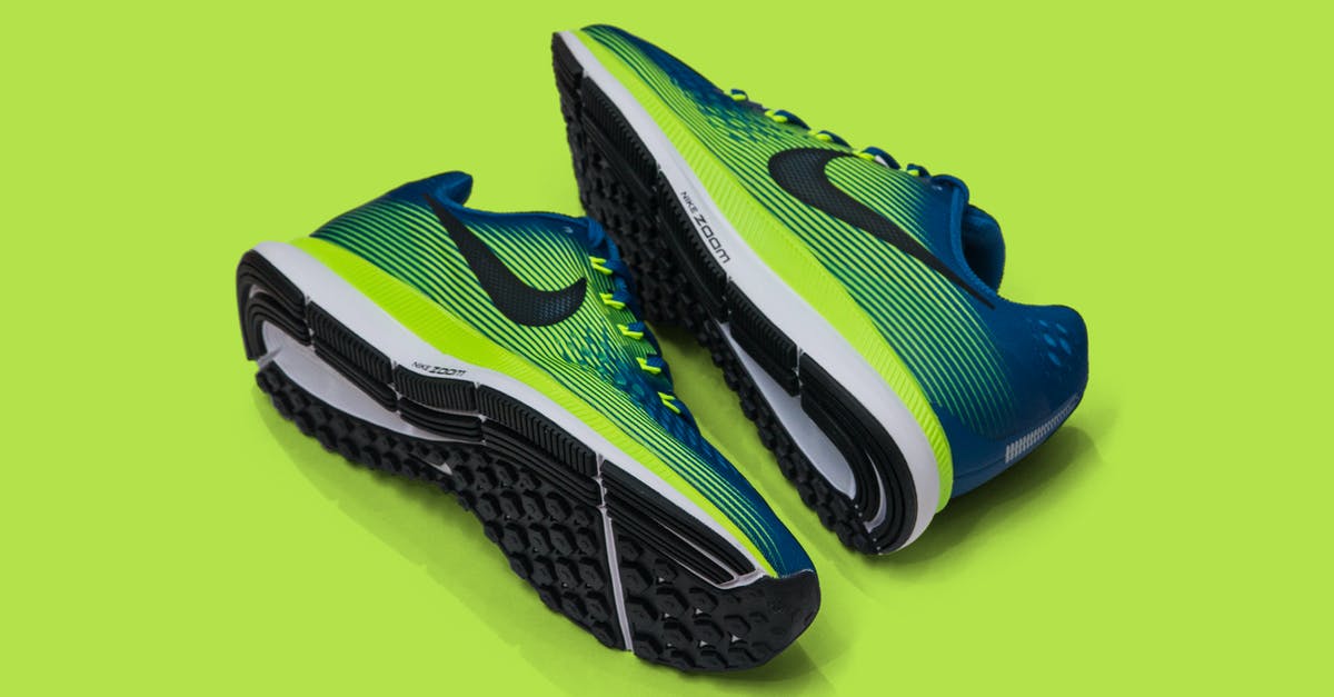 What fruit pair well with spinach? - From above of colored sneakers with blue and green surface and green and white and black sole for comfortable moving around streets against green background