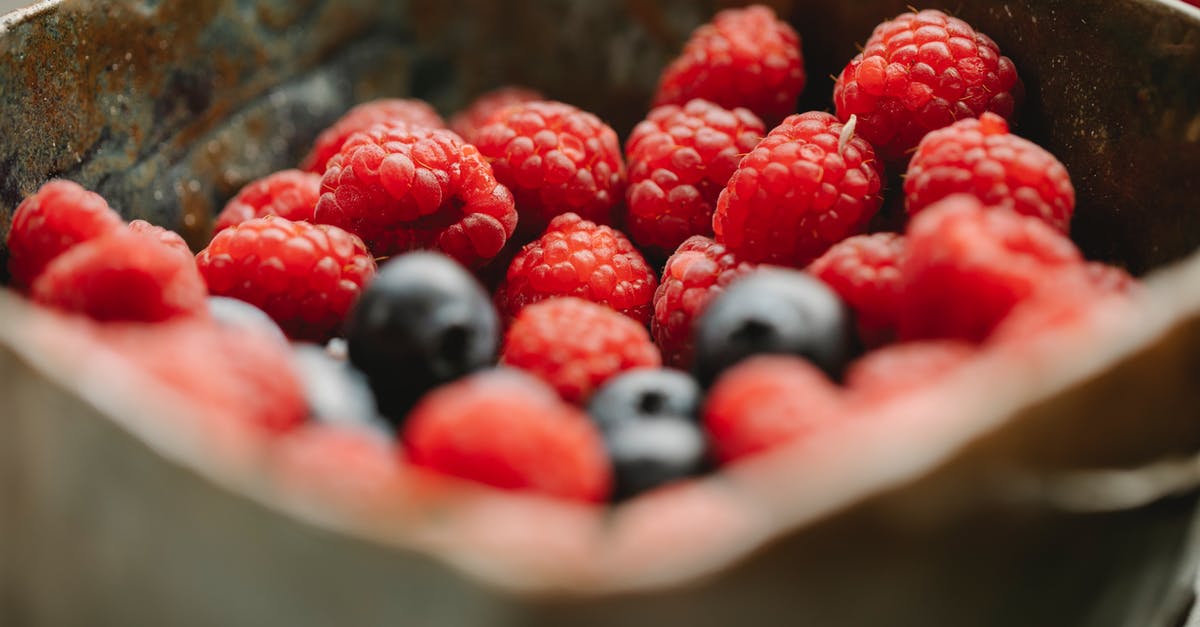 What fruit pair well with spinach? - Appetizing ripe raspberries and blueberries in bowl