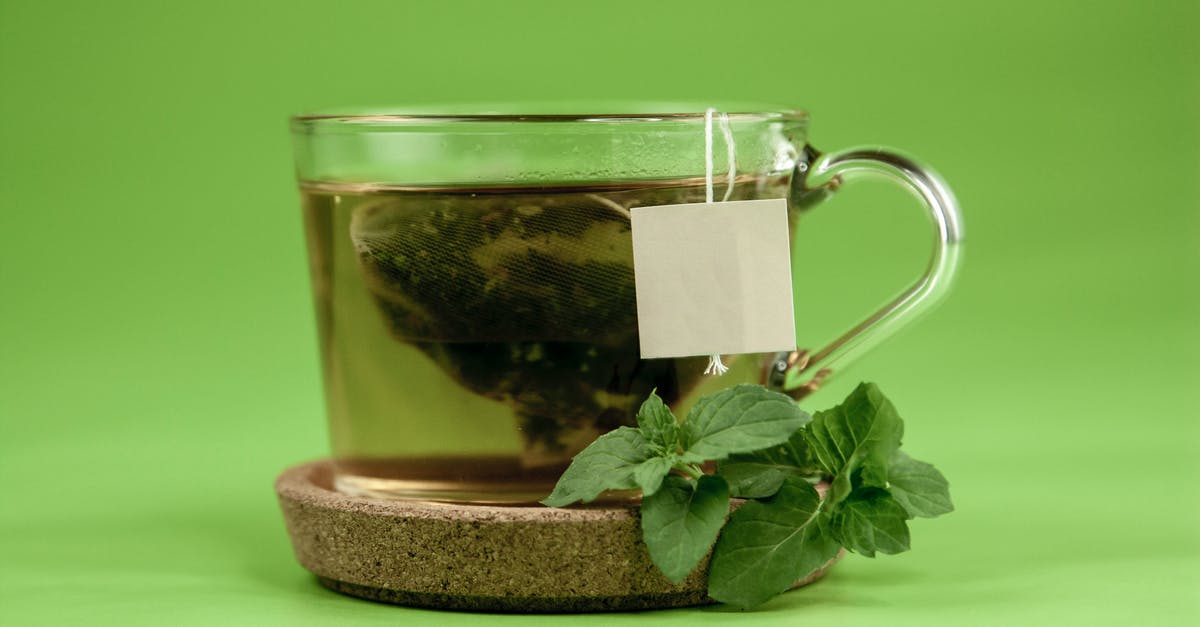 What green tea has the highest caffeine content? - Transparent cup of green tea with mint