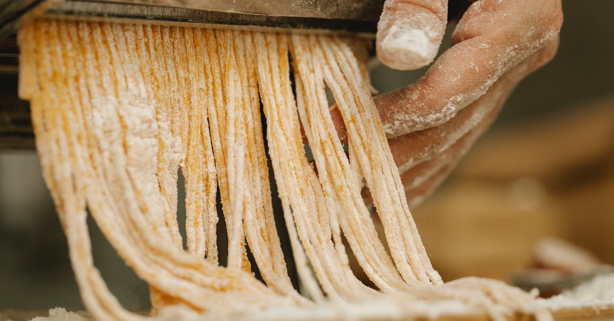 What happens to pasta dough when it is run multiple times through the machine? - Crop unrecognizable chef preparing spaghetti from uncooked dough with flour using pasta rolling machine in kitchen What happens to pasta dough when it is run multiple times through the machine? - Crop unrecognizable chef preparing spaghetti from uncooked dough with flour using pasta rolling machine in kitchen
