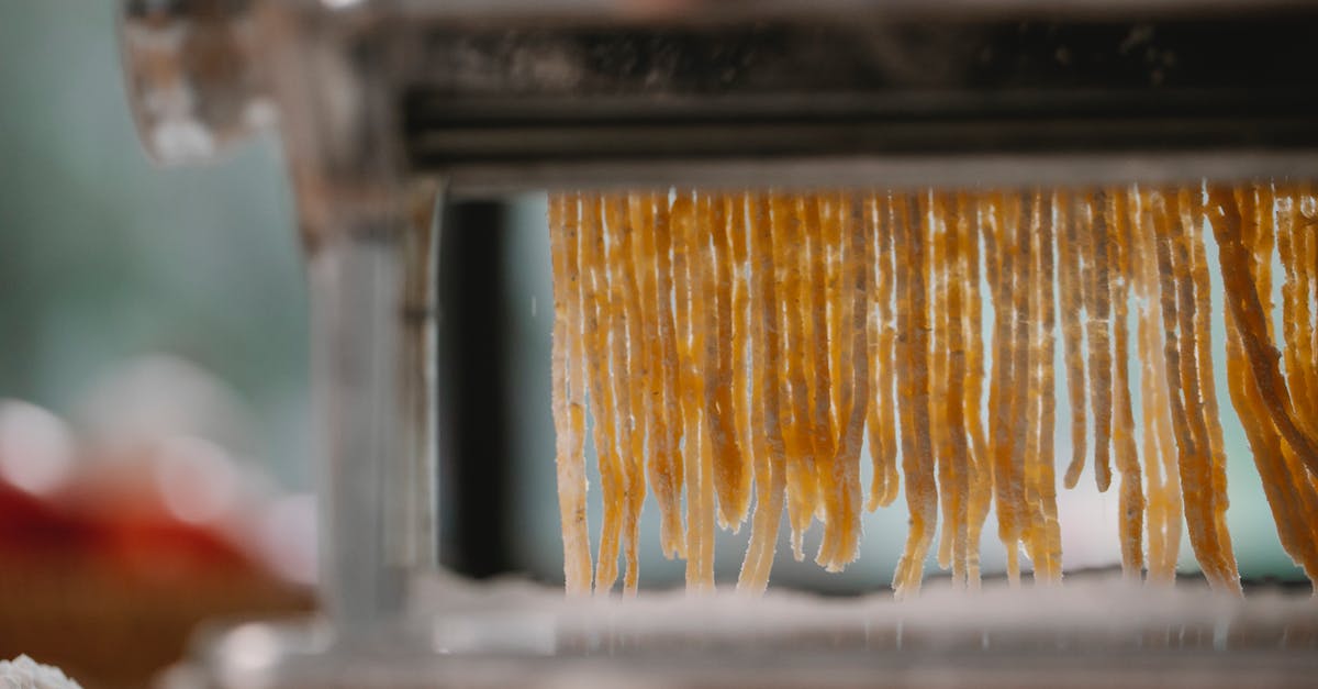 What happens to pasta dough when it is run multiple times through the machine? - Process of cutting pasta with machine on kitchen What happens to pasta dough when it is run multiple times through the machine? - Process of cutting pasta with machine on kitchen