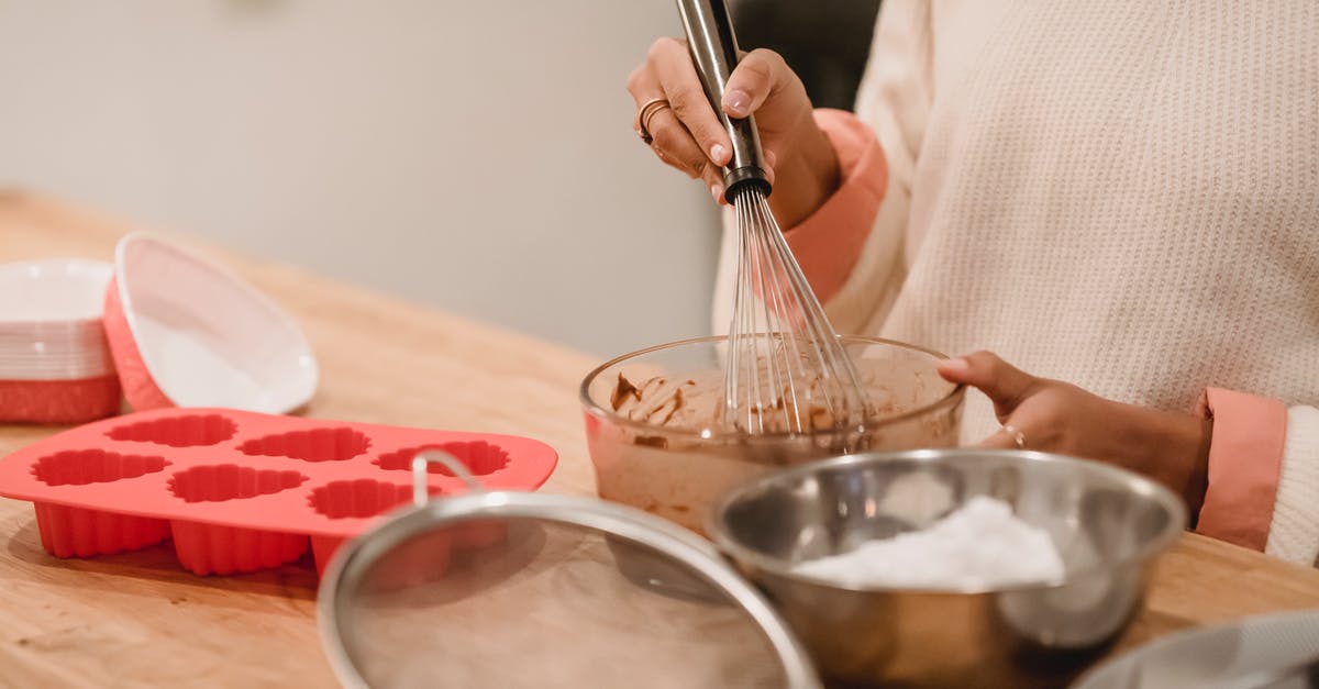 what happens when one mixes flour into batter? - Crop woman mixing batter in kitchen